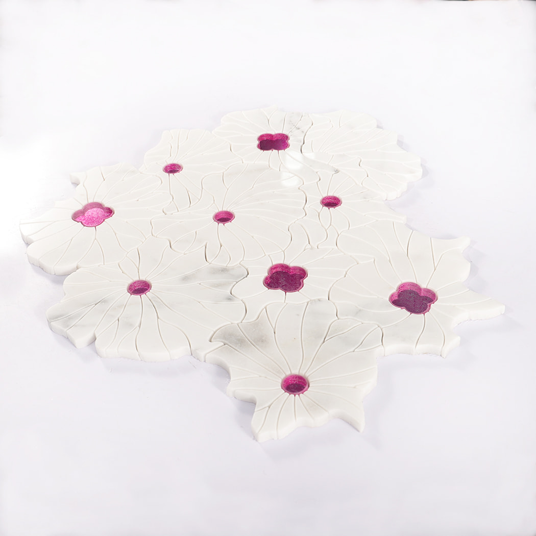 Angled view of flower-shaped white marble mosaic tile with pink glass accents.