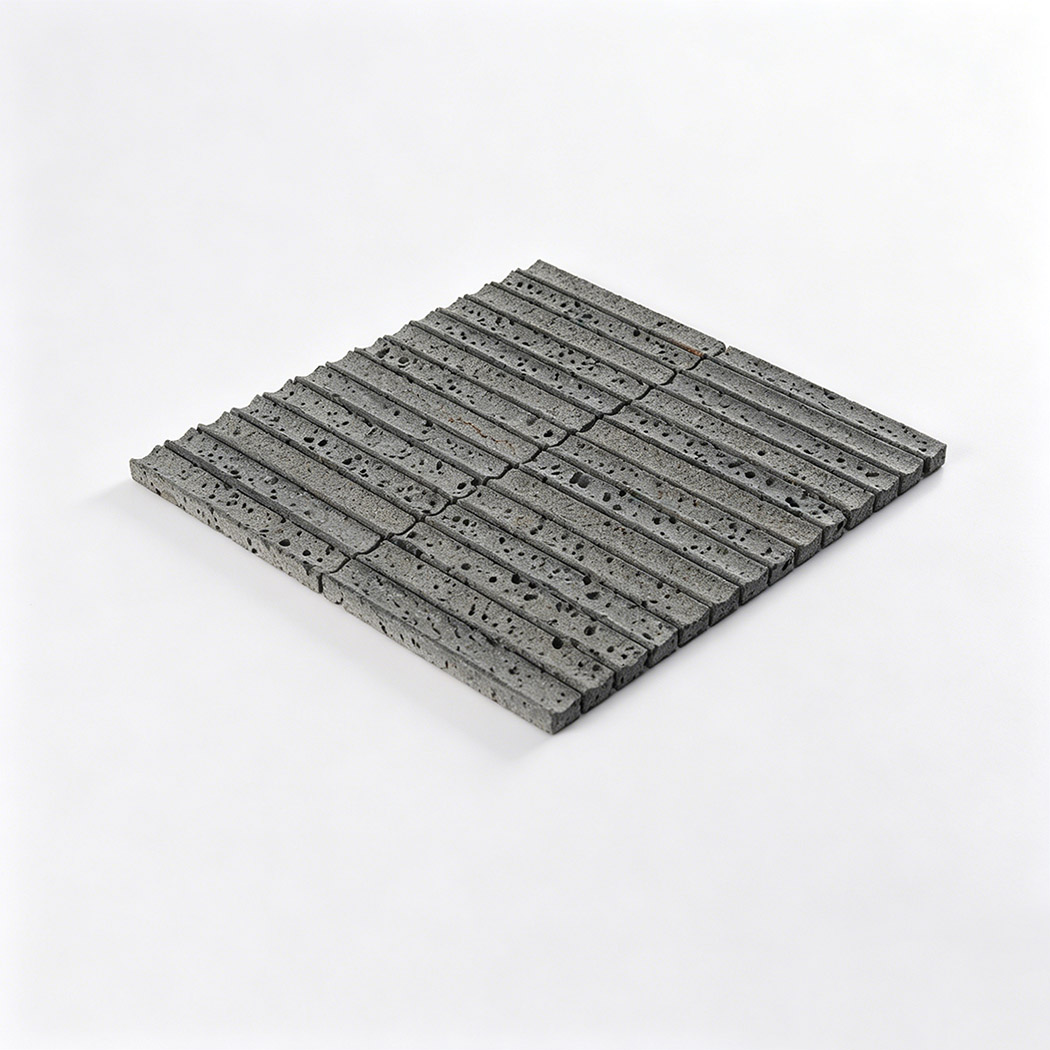 Angled view of gray lava stone linear mosaic tile sheet with textured strip surface