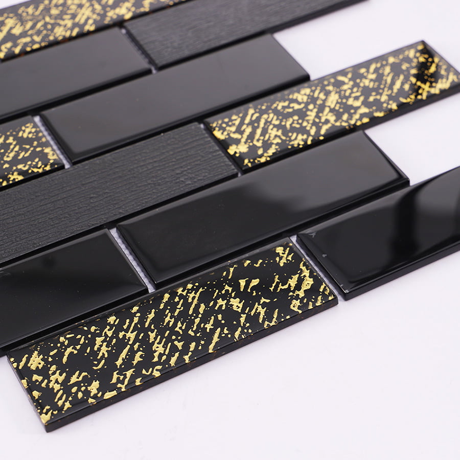 Angled view of black and gold glass mosaic subway tile showing depth and shine