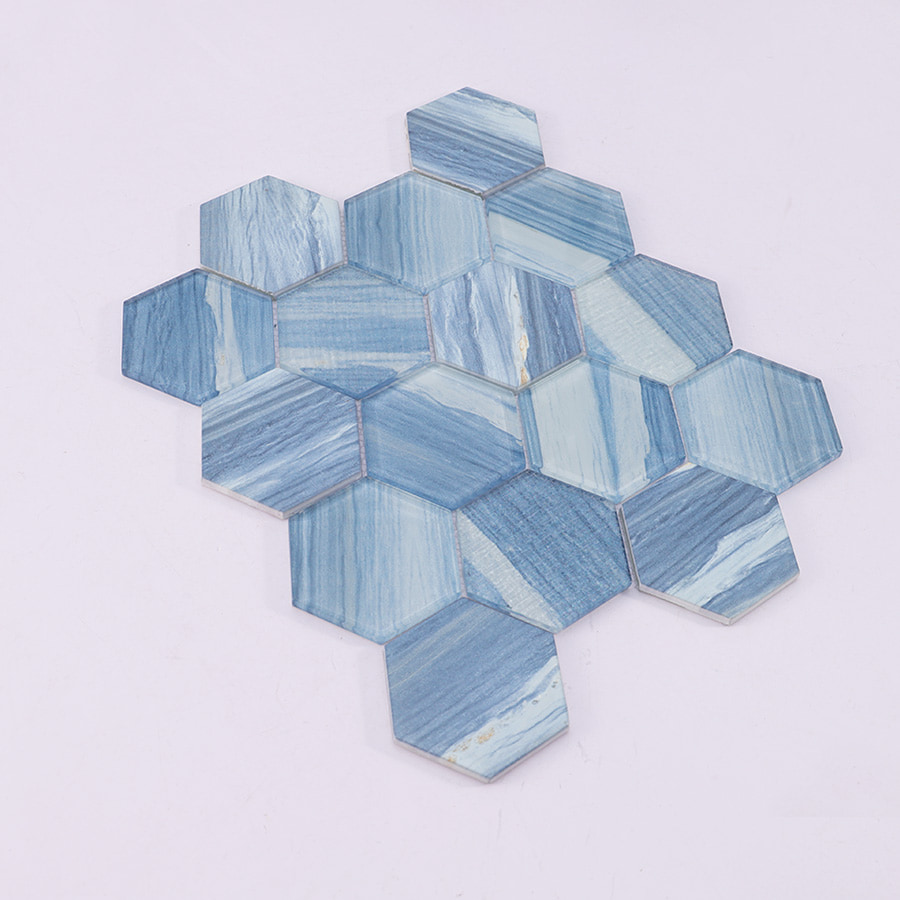 Angled view of blue hexagon glass mosaic tile sheet showing 3D surface depth