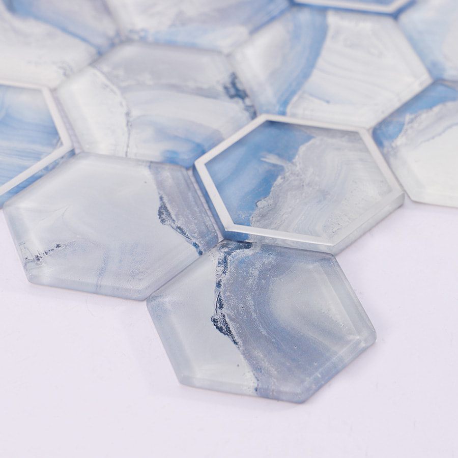 Angled view of blue and white hexagon glass mosaic tile sheet showing depth