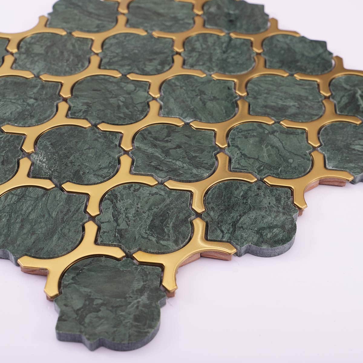 Angled view of gold and green marble arabesque mosaic tiles
