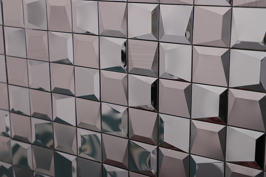 Angled perspective of beveled reflective metal 3D square tiles forming geometric texture