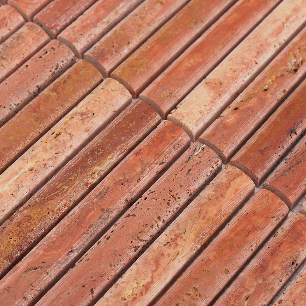 Perspective view of the rounded edges and textured surface of red travertine mosaic strips.