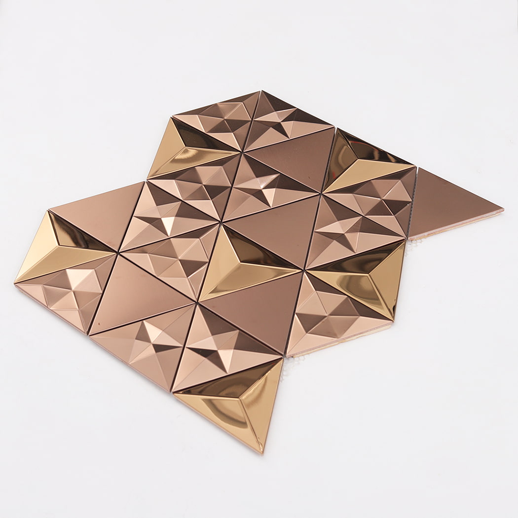 Perspective view of a rose gold 3D triangular mosaic sheet on a white surface.