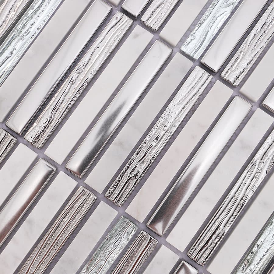 Angled close up of silver glass and textured white marble mosaic tile