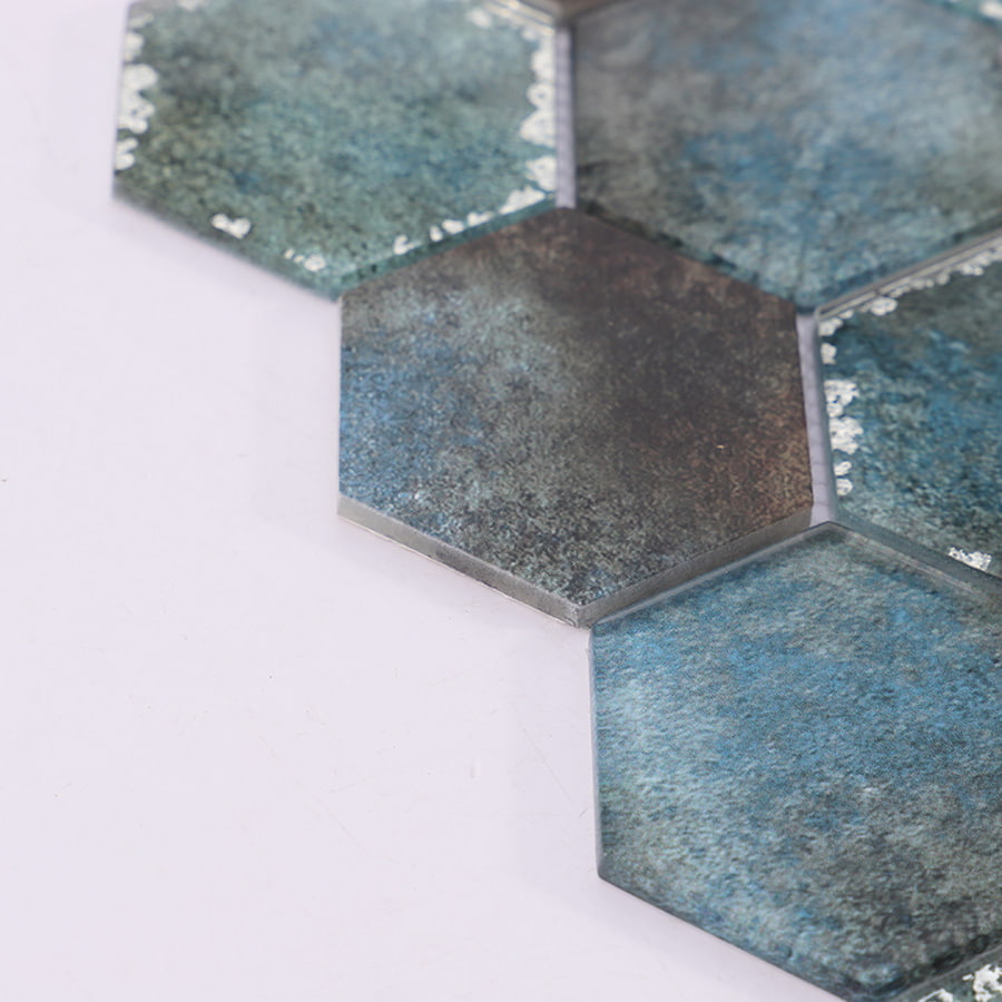 Angled view of teal hexagon glass mosaic tile sheet with reflective surface