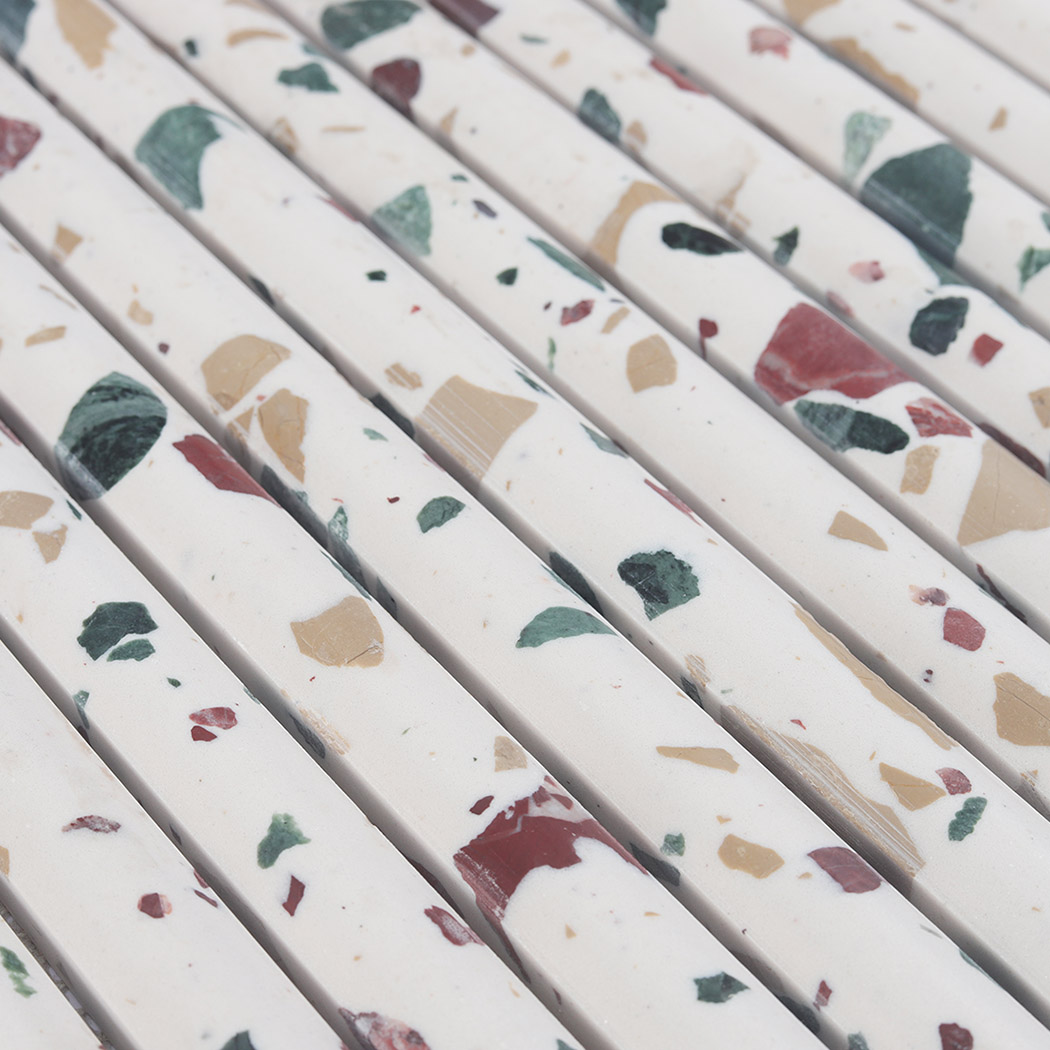Angled close-up of white terrazzo rounded fluted mosaic tile surface