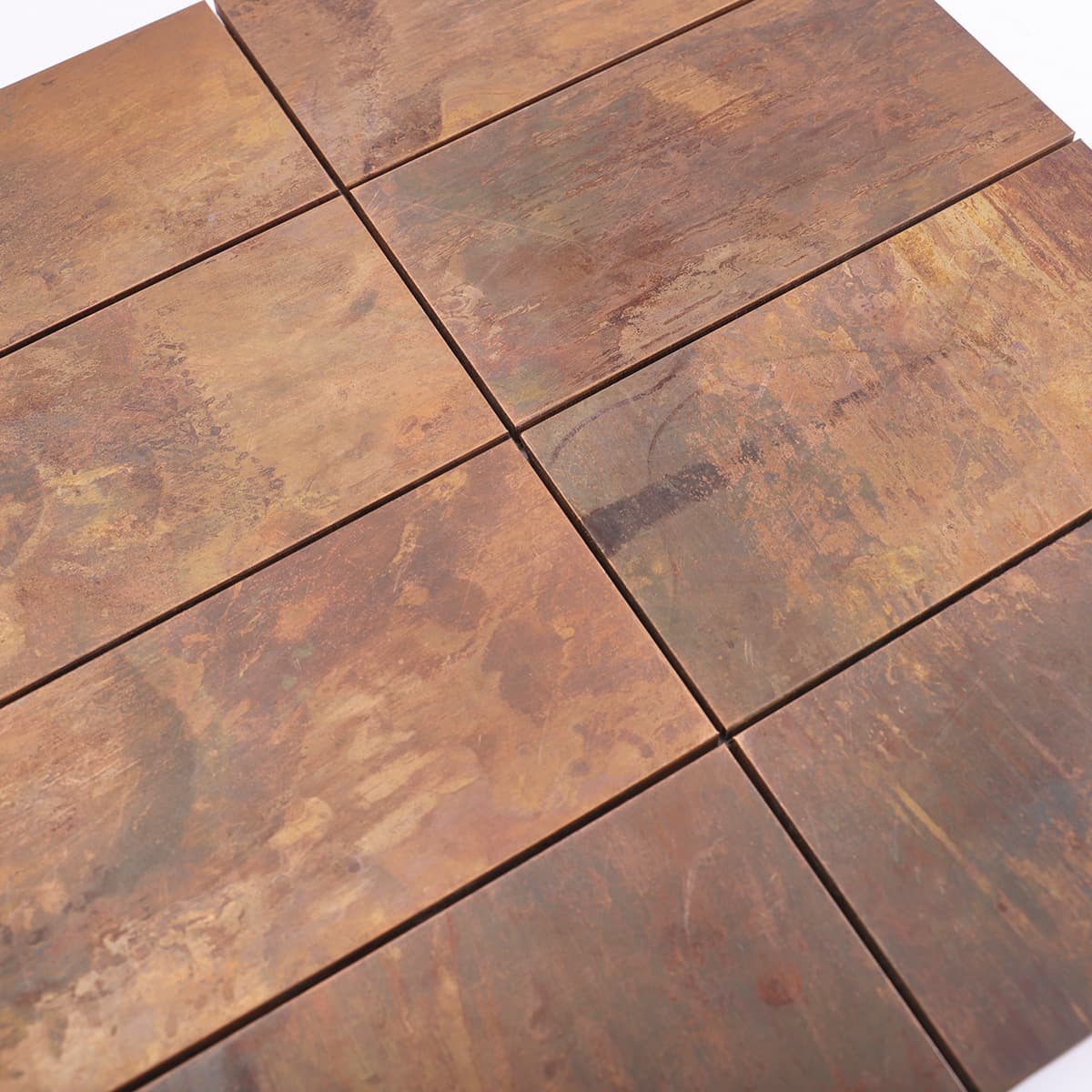 Textured surface of rustic copper mosaic tiles