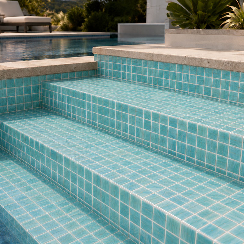 Aqua pool step tiles covering outdoor pool steps and risers with white grout