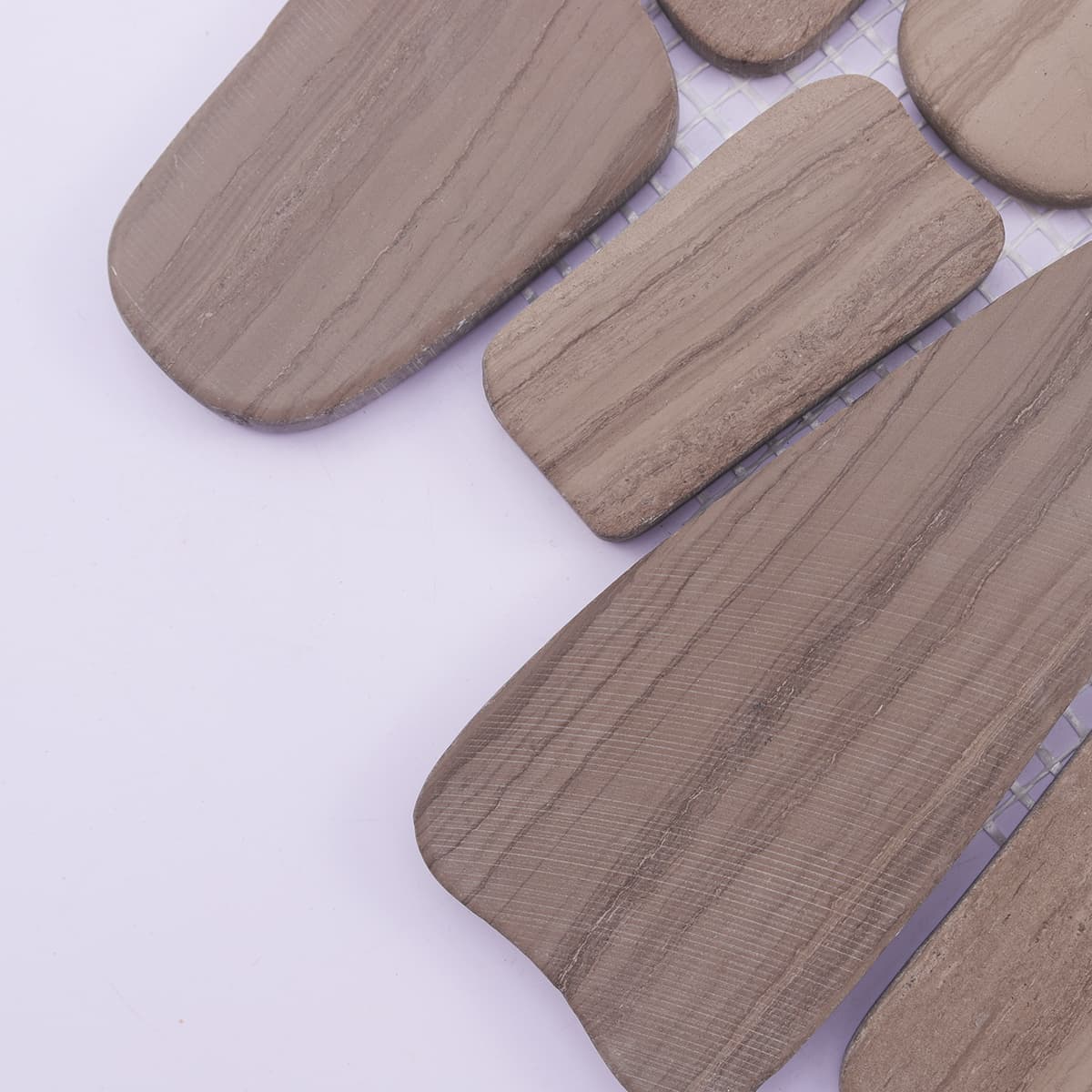 Corner close-up showing smooth edges of flat pebble stone tile