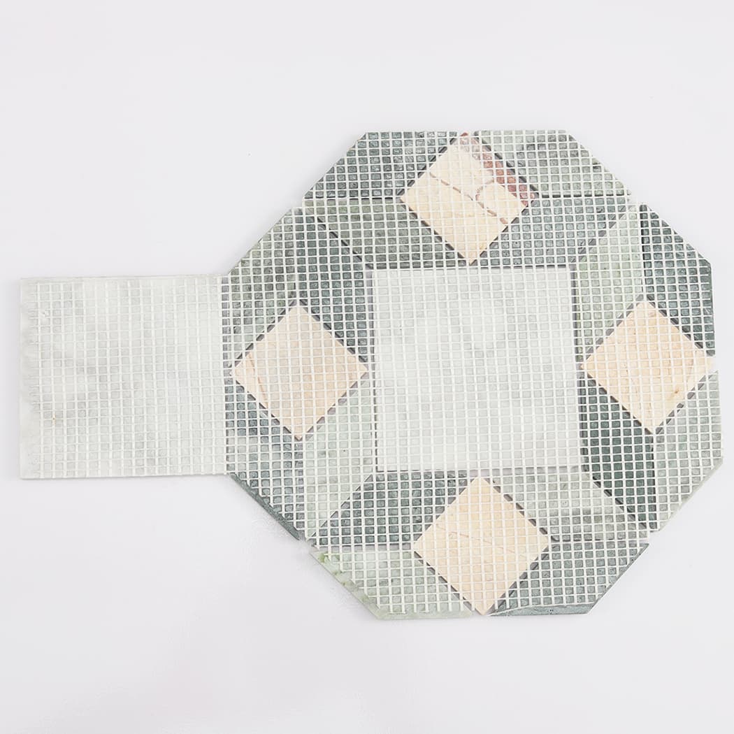 Rear view of a geometric marble tile sheet showing the mesh backing for easy installation.