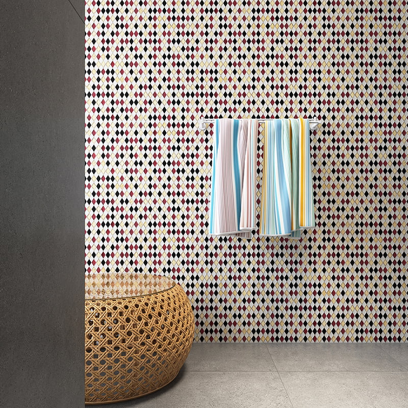 Modern bathroom wall with red, black, white and gold diamond mosaic tiles and striped towels