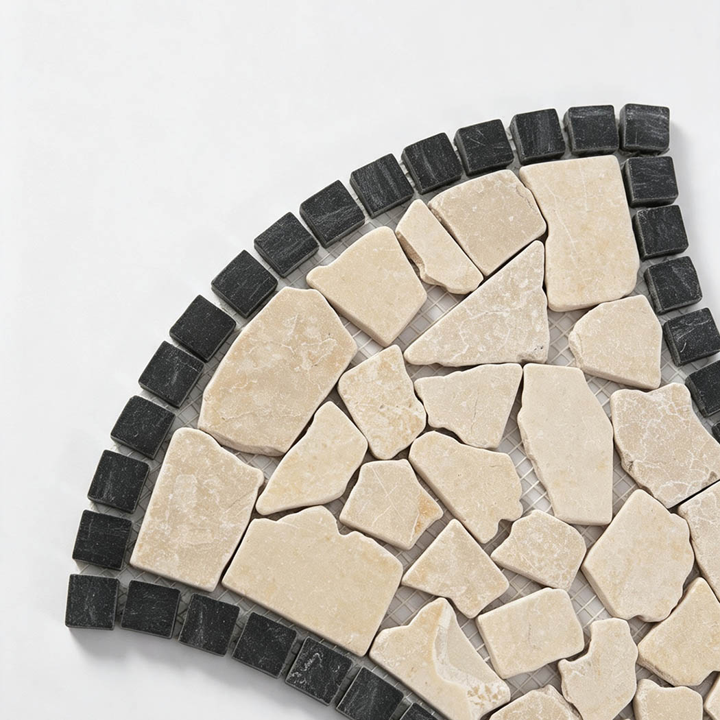 Close-up of beige irregular marble pebbles with dark charcoal border tiles