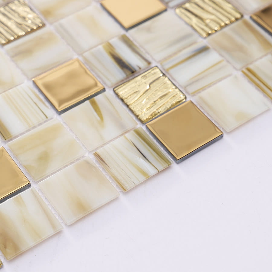 Angled view of beige mosaic tile sheet with glossy gold accents