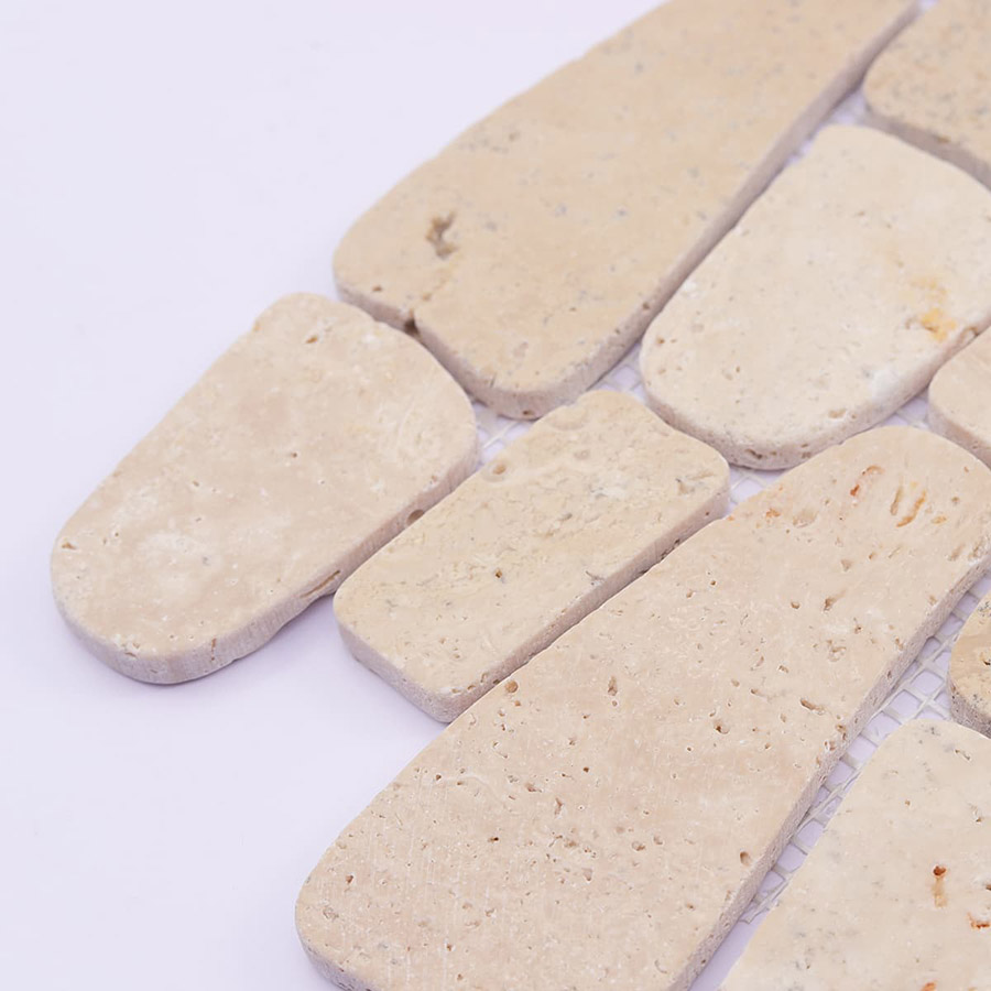 Close-up of edges and surface of beige pebble mosaic tiles