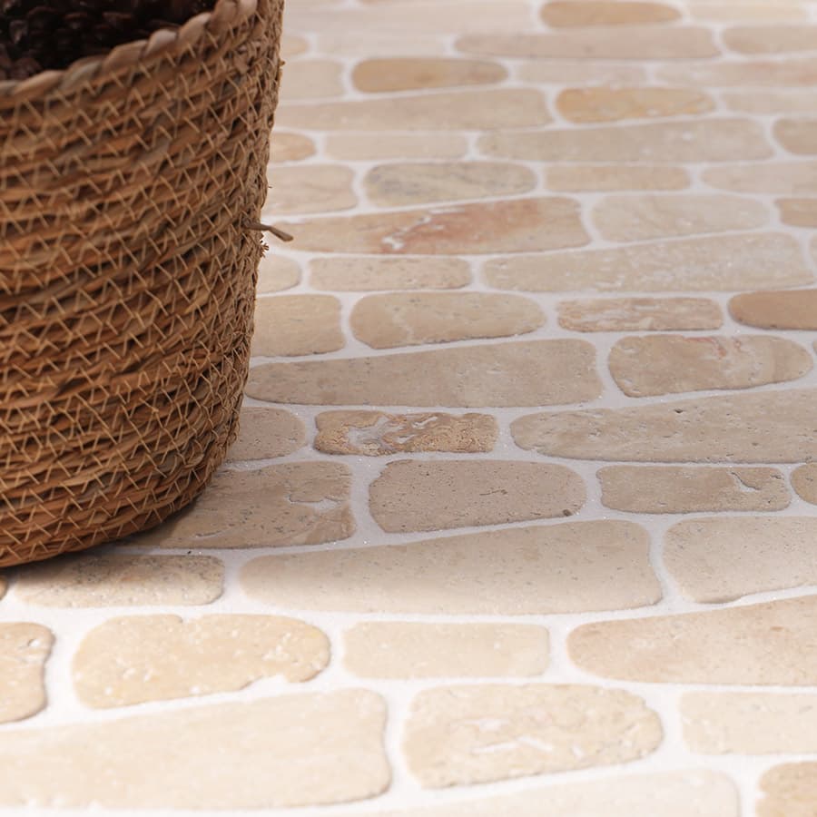 Close-up of beige stone mosaic tiles with woven basket