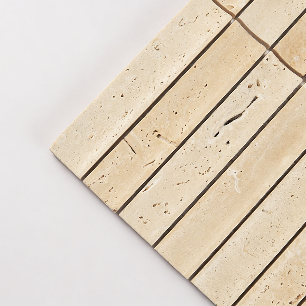 Close-up angled view highlighting the texture and depth of beige travertine stacked mosaic