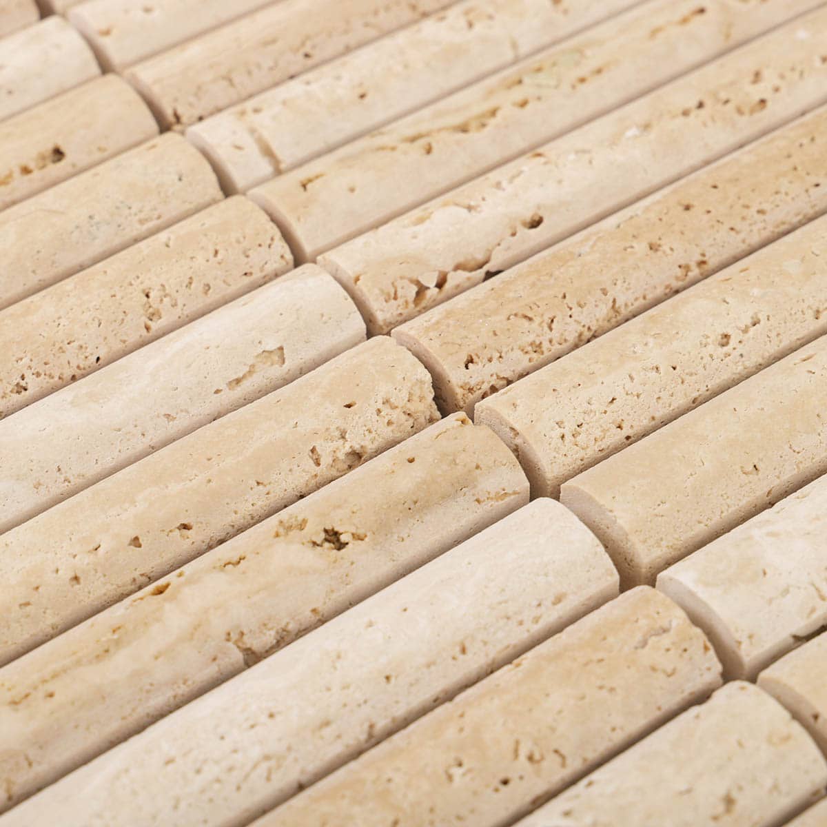 Angled detail of beige travertine stick mosaic tiles