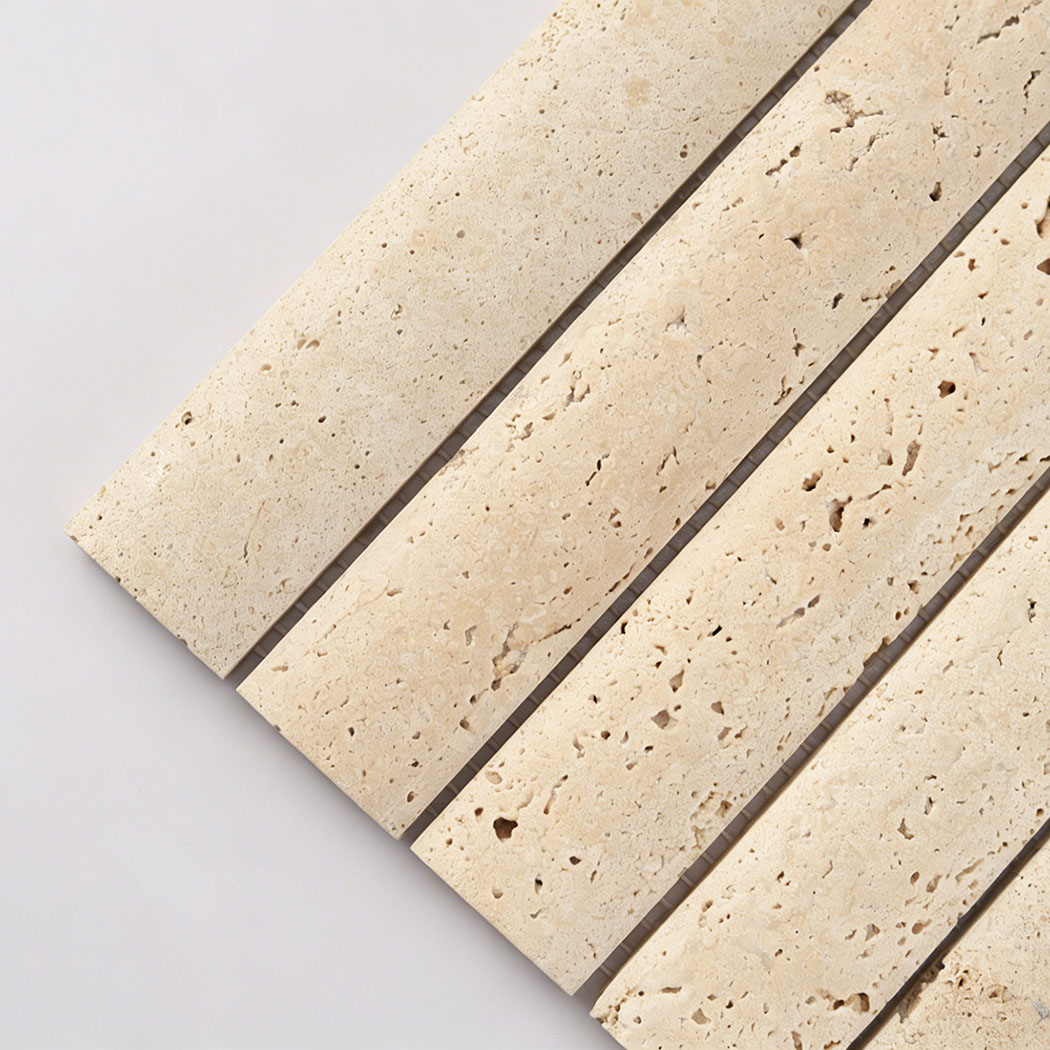 Close up of beige travertine wide linear tile showing natural holes and cream tones