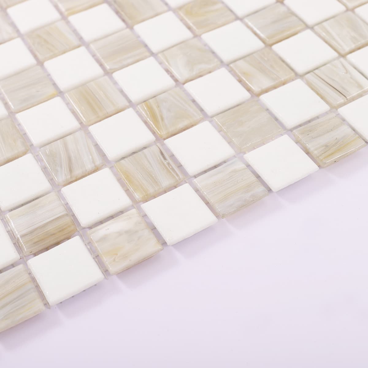 Bottom edge view of beige and white checkered glass mosaic tile