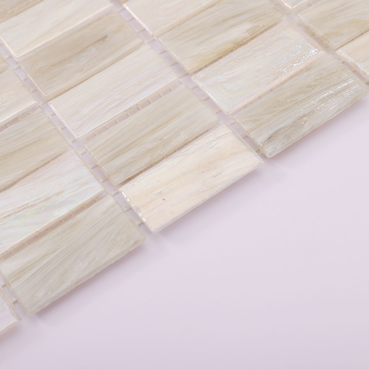 Edge detail of beige and white checkered iridescent rectangular mosaic tile