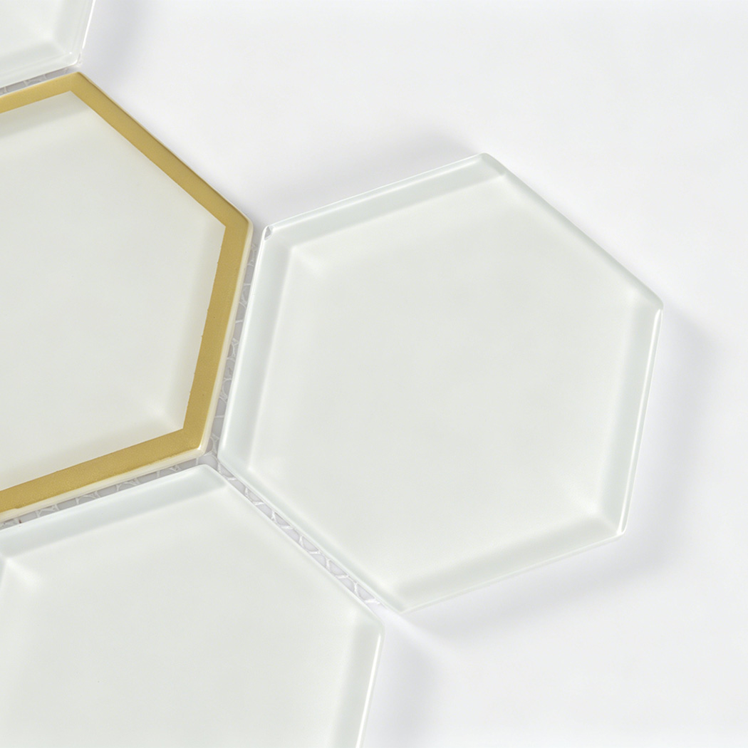 Close detail of white beveled hexagon glass tile with electroplated gold glass frame