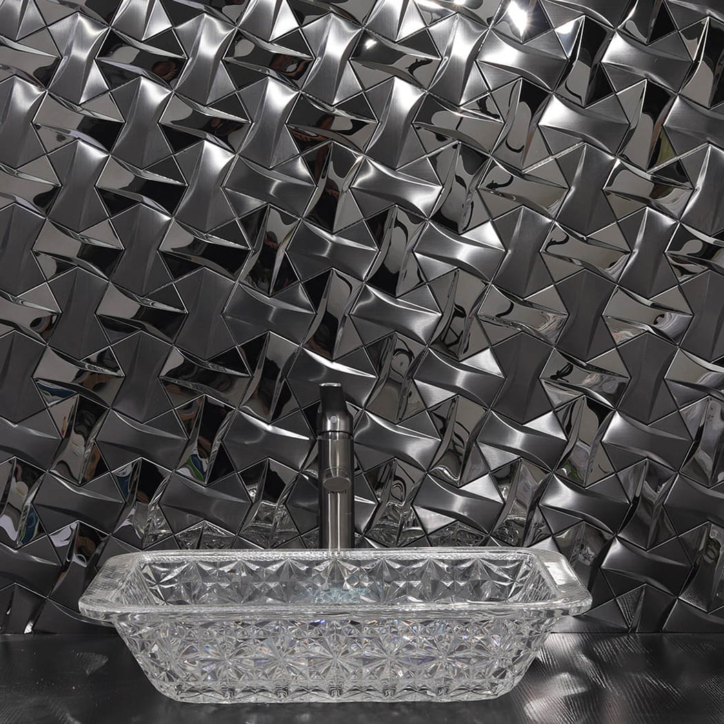 Black 3D geometric tile backsplash installed behind a modern glass bathroom sink.