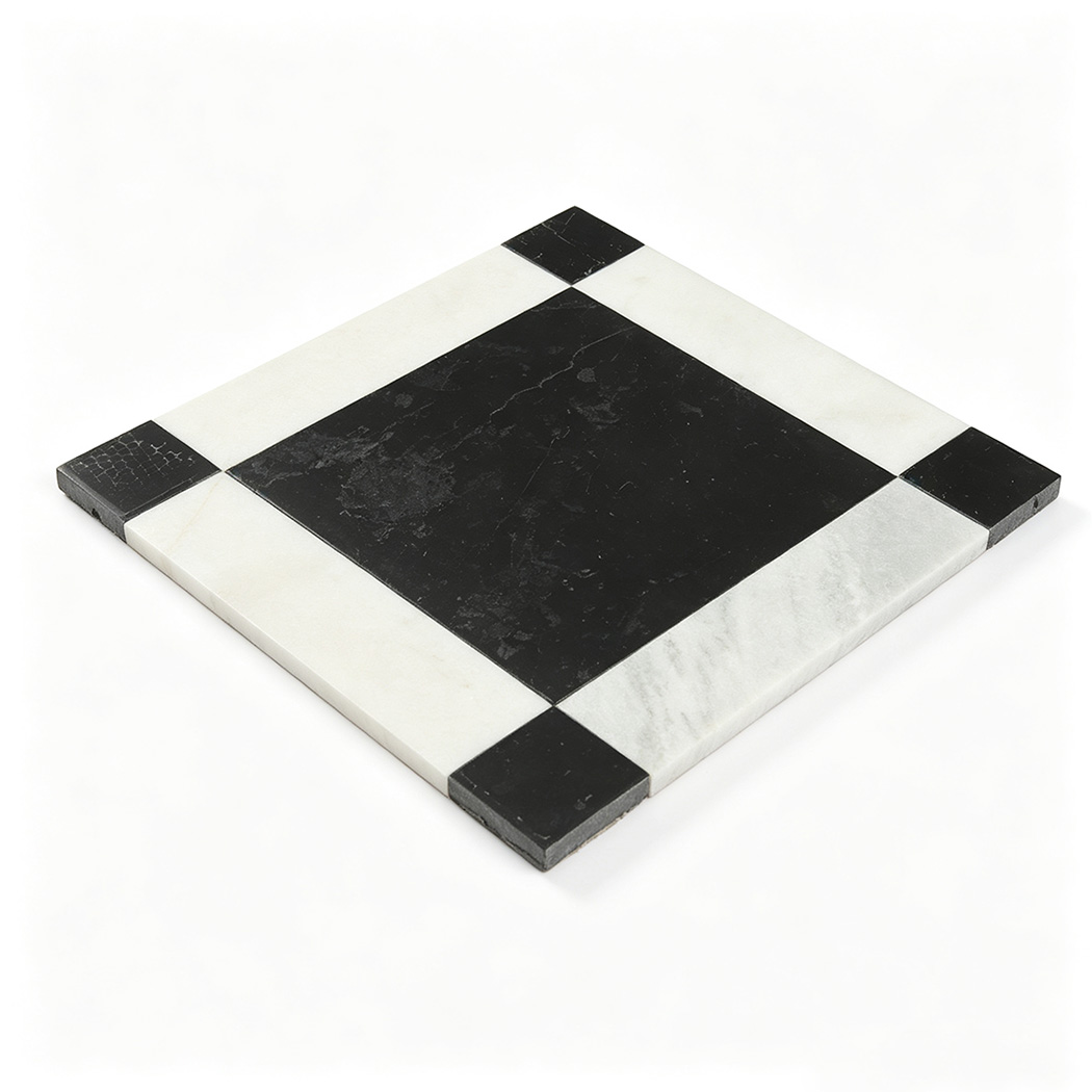 Angled view of a black and white marble mosaic tile with a square border