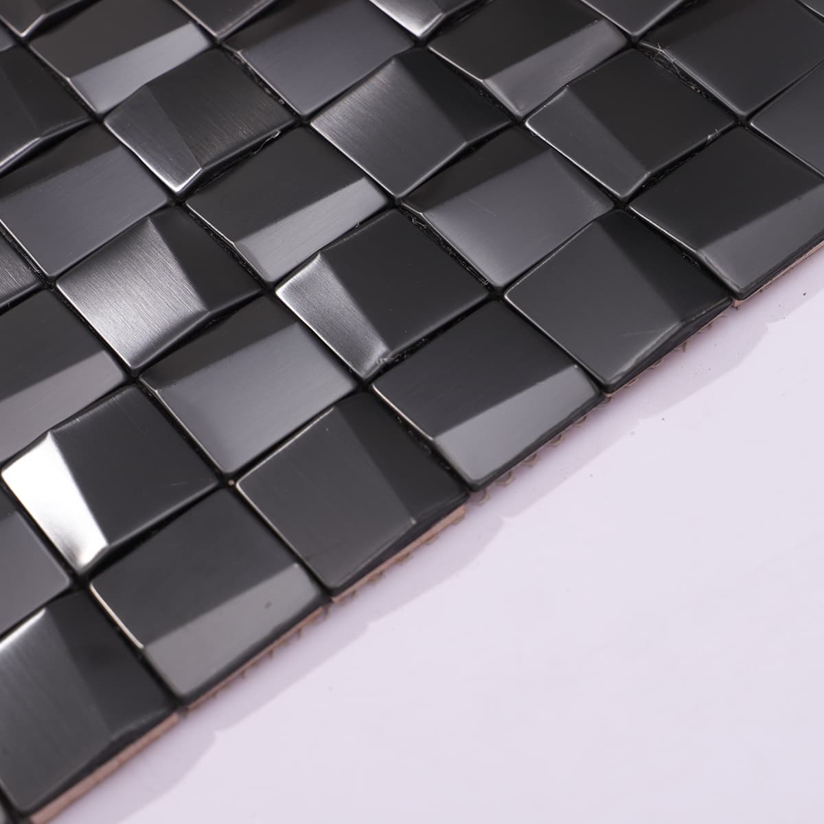 Edge detail of 3D brushed black stainless steel mosaic tile