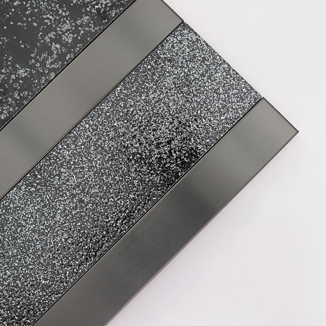 Close-up of black electroplated stone tile with brushed stainless steel strips