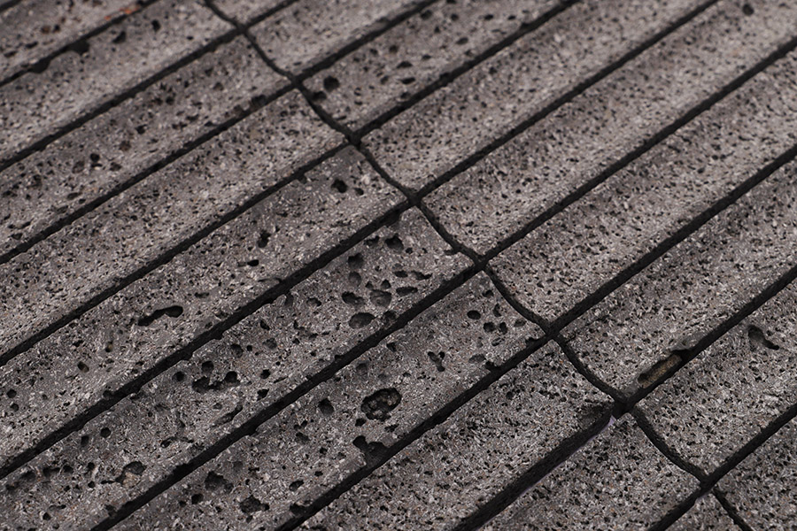 Black fluted tiles textured linear pattern, close-up of grooved surface