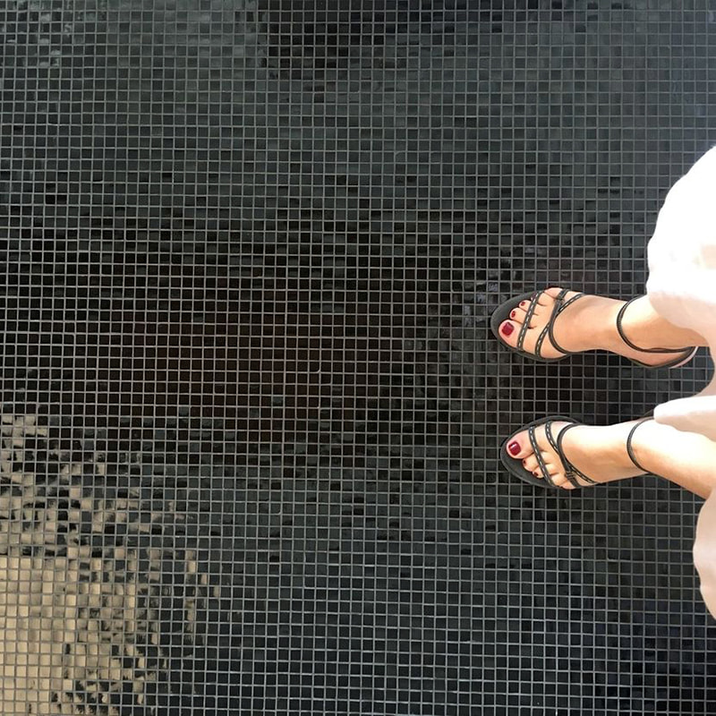 Glossy black glass mosaic tile flooring with subtle reflections