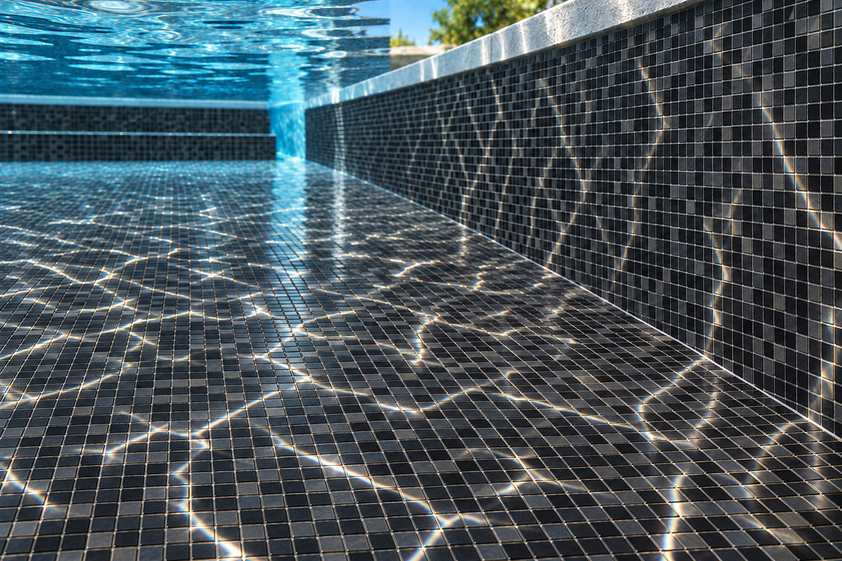 Black glass mosaic pool tiles on the floor and wall with sunlight reflections