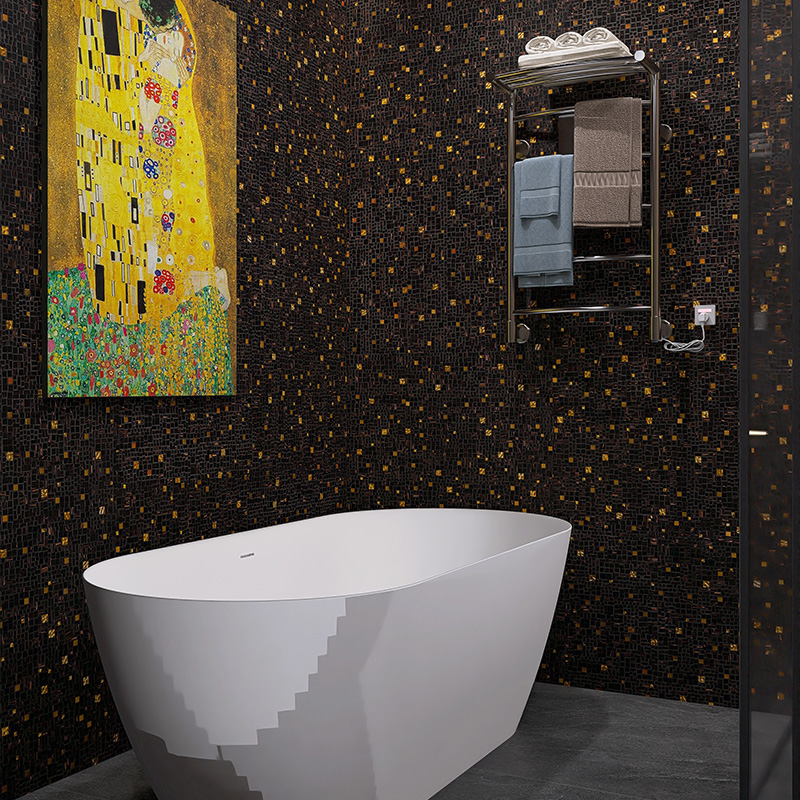Bathroom with black and gold mosaic walls and a freestanding bathtub