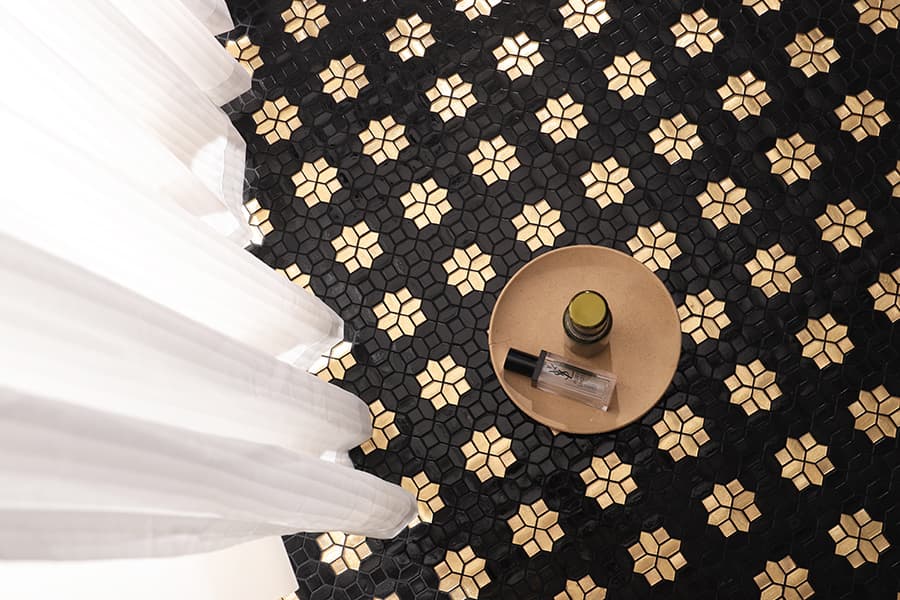 Geometric black and gold star mosaic tiles used for elegant flooring