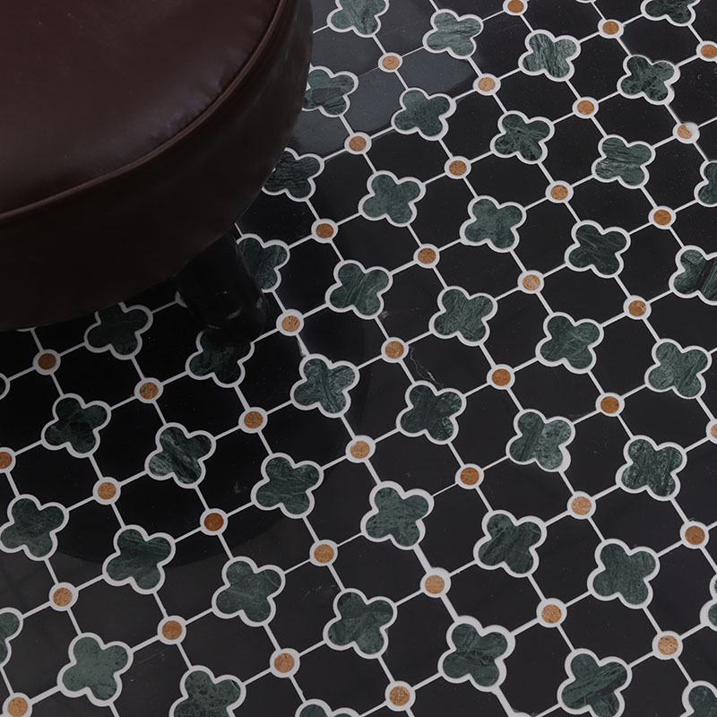 Black and green clover mosaic floor tile close-up with gold dot accents