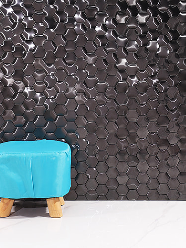 Close-up of glossy black hexagon tiles with a modern finish and a blue stool 