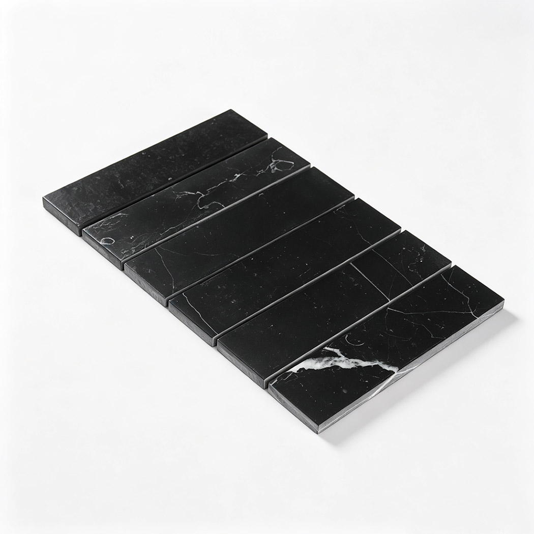 Angled view of a black linear marble mosaic sheet with natural white veining