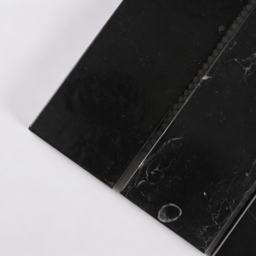Close-up of black marble strips with white veins and natural fossil markings
