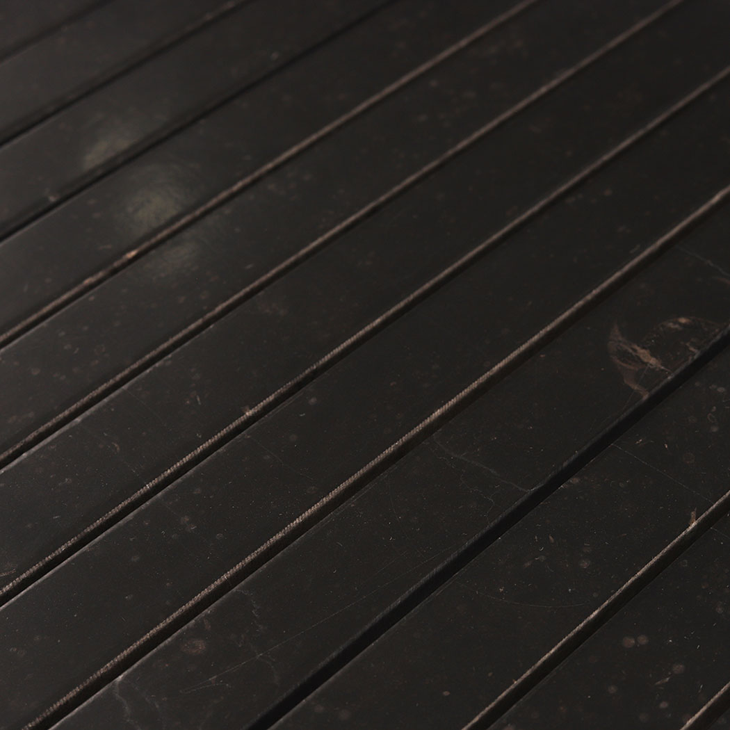 Detailed view of natural fossil markings on black marble mosaic strips