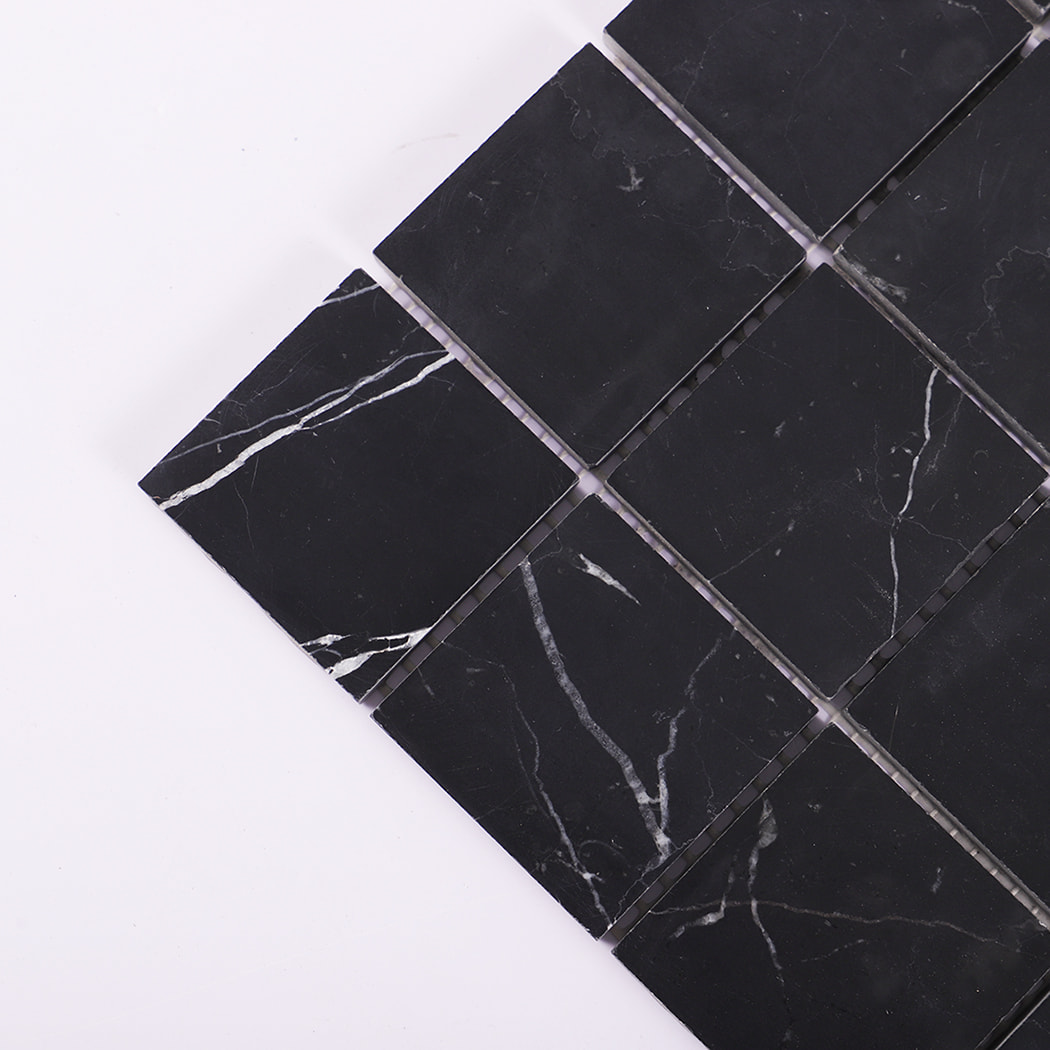 Close-up of the corner section of black marble mosaic tile squares.