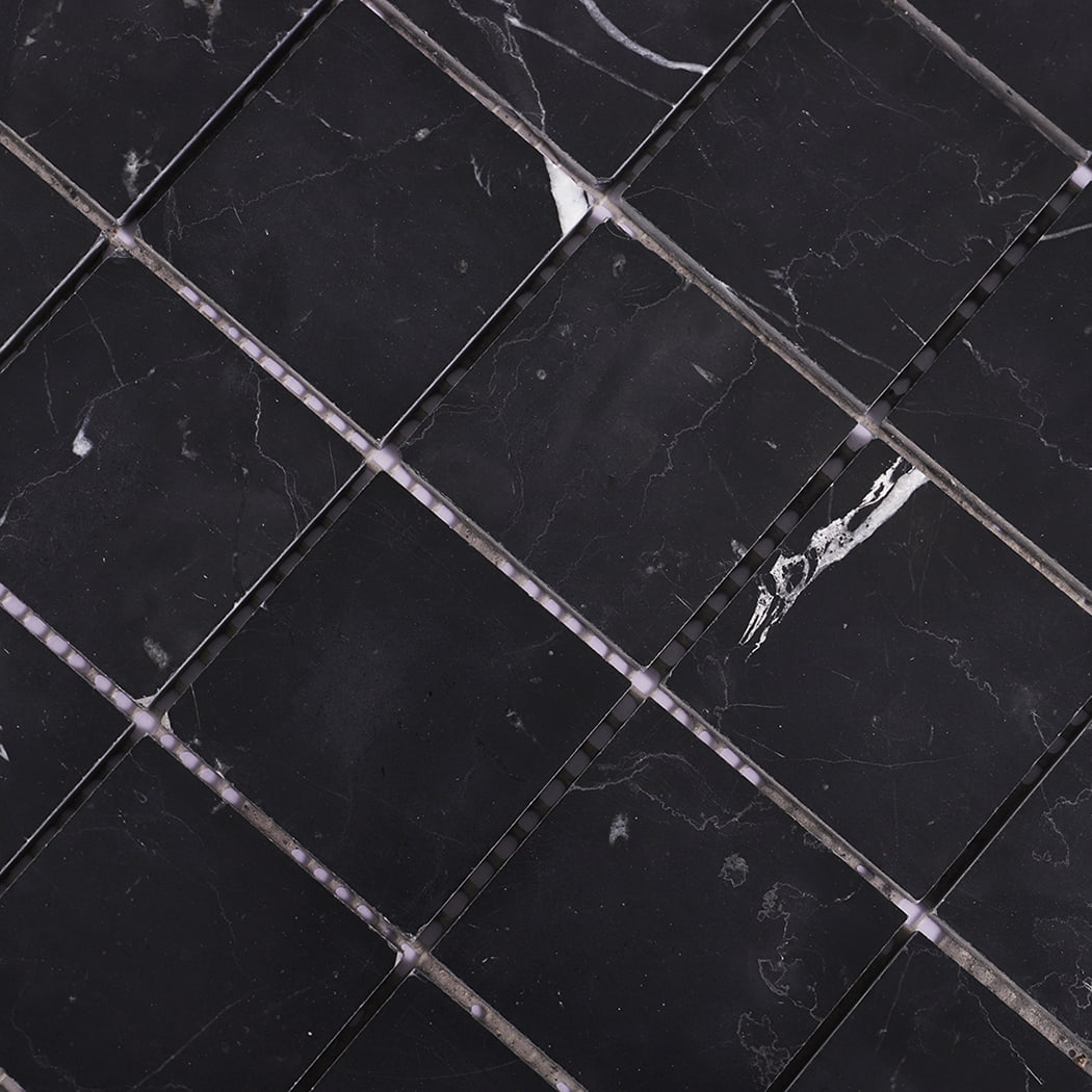 Diagonal close-up showing details of black marble mosaic tile texture.