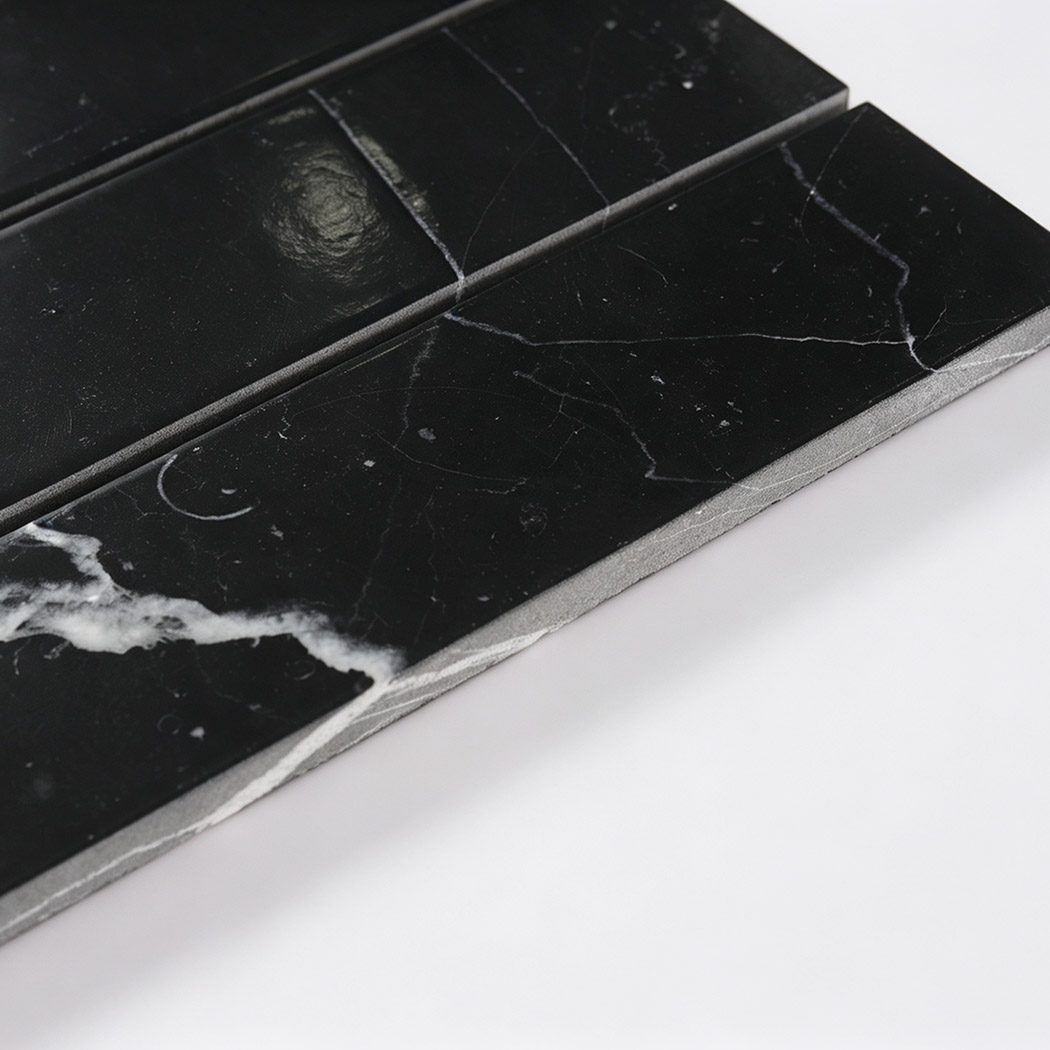 Angled close-up showing the polished surface and thickness of black marble strips