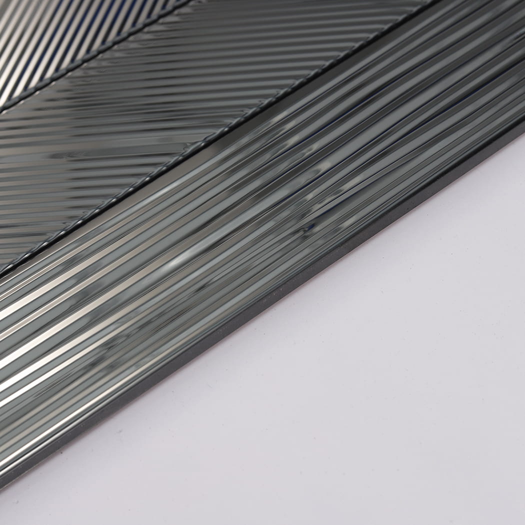 Side detail of black mirror stainless steel tile showing grooved texture and edge thickness