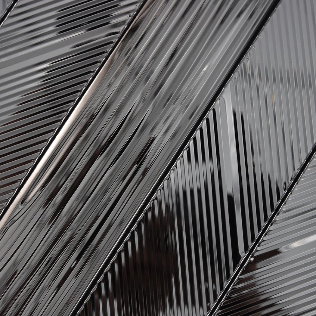 Close-up of black mirror stainless steel surface with vertical and diagonal grooves