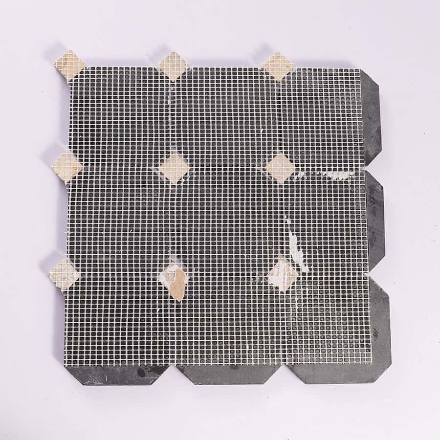Back view of black octagon marble mosaic with mesh backing
