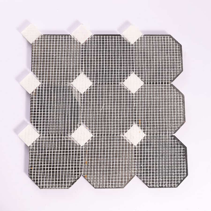 Back view of black octagon marble mosaic with mesh backing