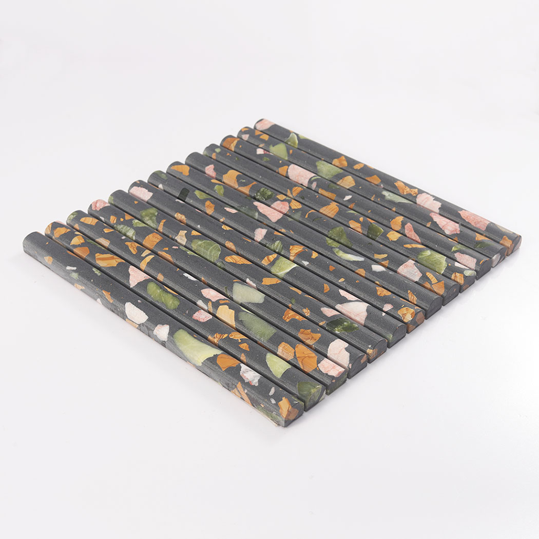 Side view of black terrazzo rounded fluted mosaic tile on a white background