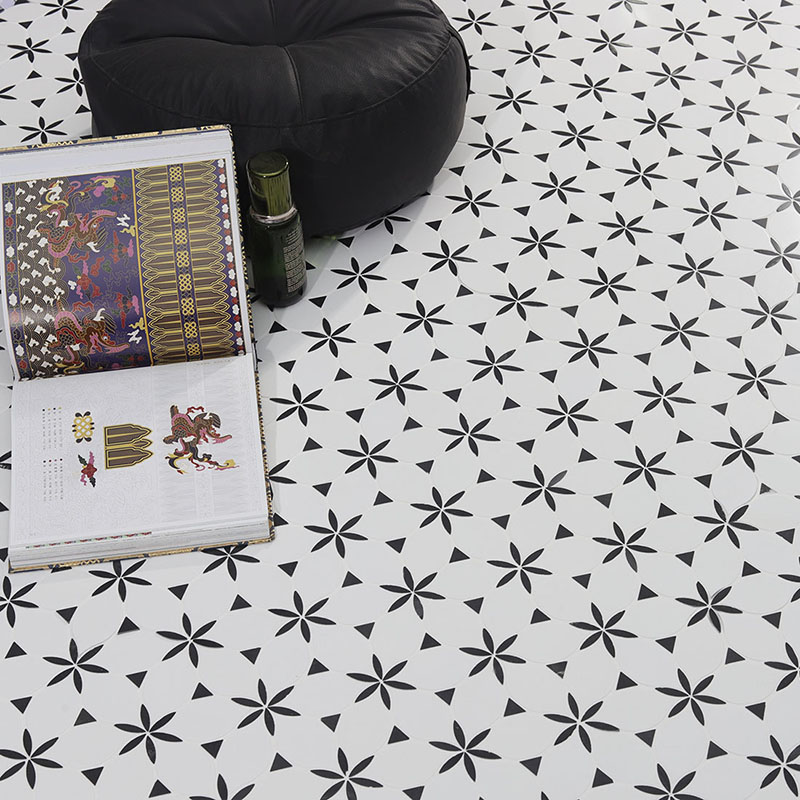 Black and white floral marble mosaic tile floor with book, bottle, and black pouf